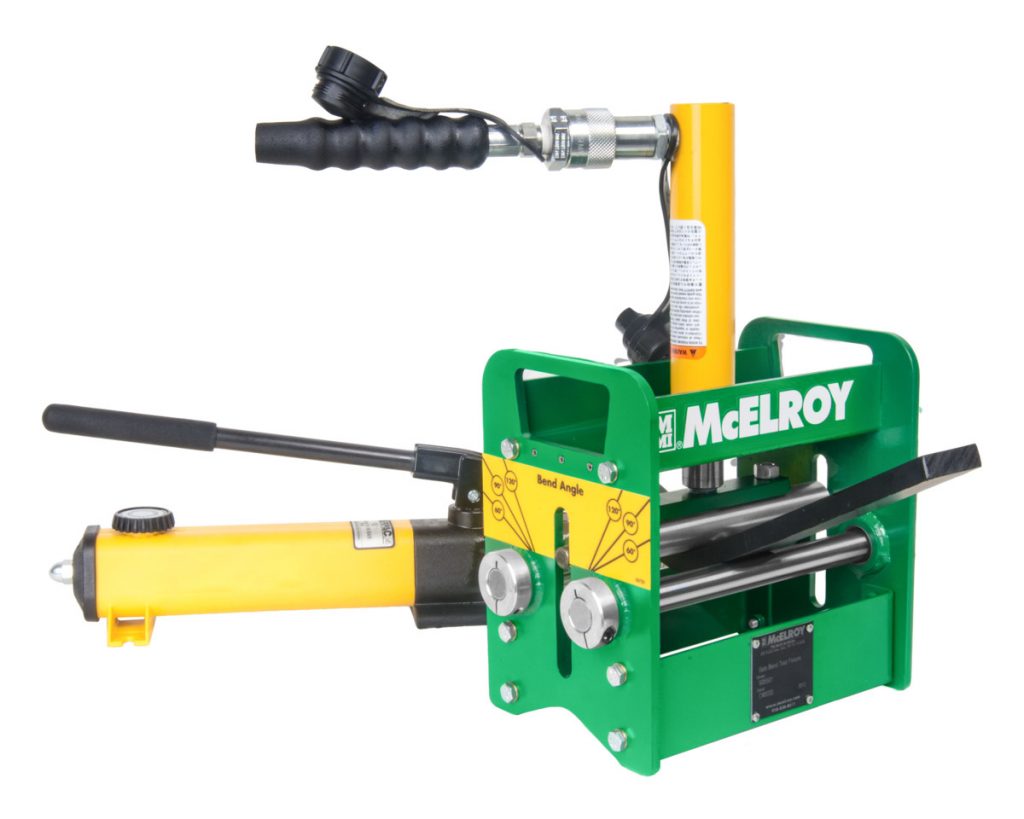 A green and yellow McElroy pipe fusion machine with black handles, labeled controls, and hydraulic components, used for joining plastic pipes together.